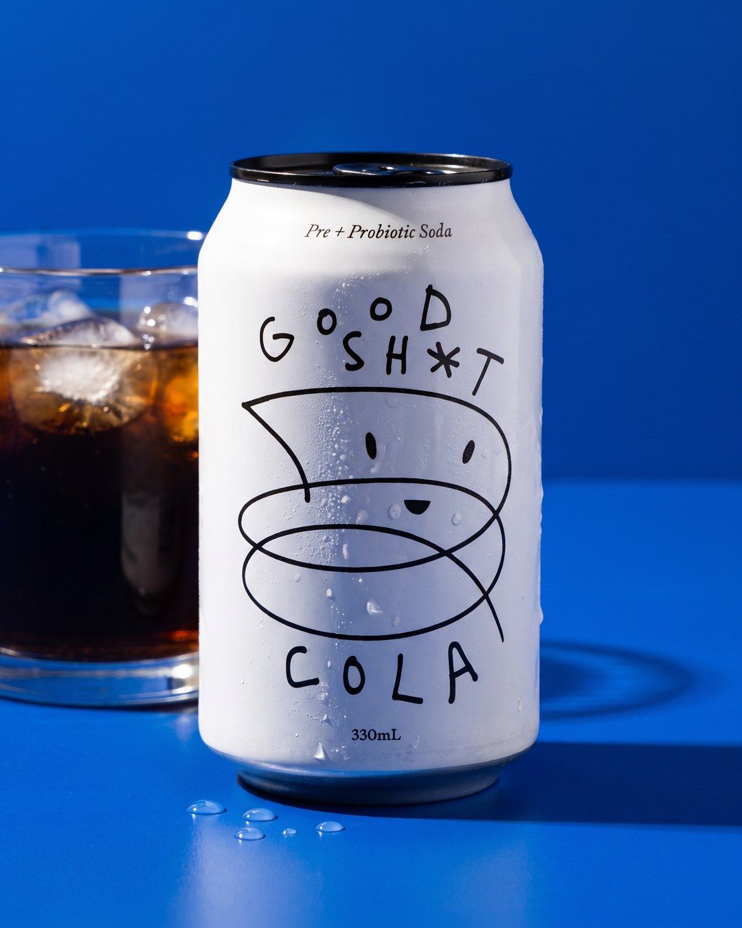 The same can on a cobalt blue set beside a glass of cola